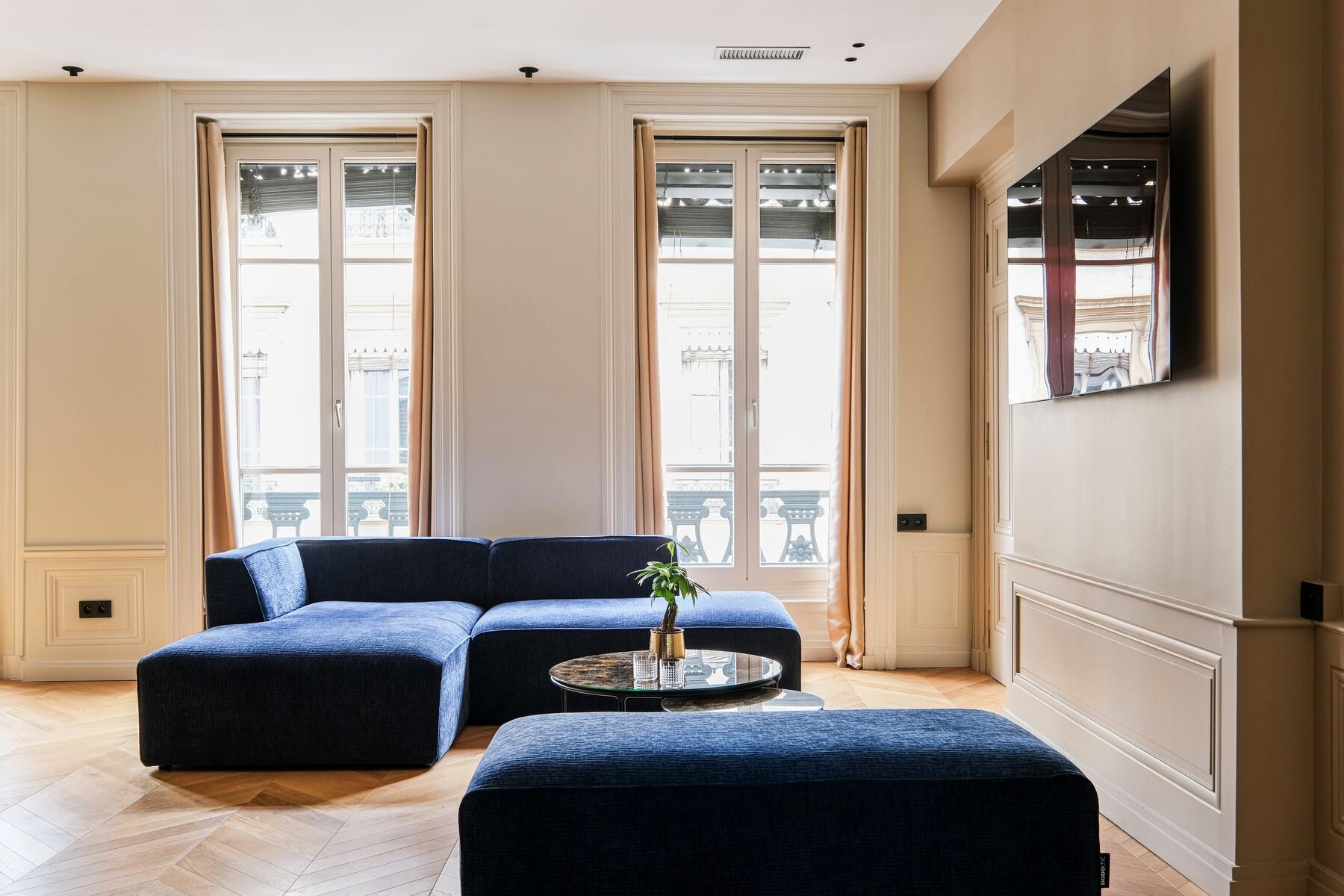 Le salon des bureaux Core Group — canapé bleu nuit et moulures